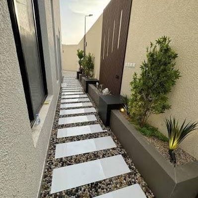 تنسيق حوش خارجي بممشى بلاط وحصى وأحواض نباتات